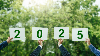 Businessman hands holding up the year 2025 with Nature background. 2025 New Year resolution concept. Business goal plan action and development for achieving goals to Sustainability environmental.