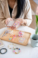 Young girl making handmade bracelets with fun and cheerfulness