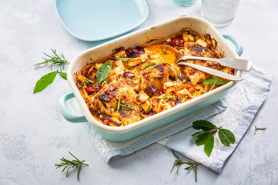 Baked chicken pieces with vegetable, tomato and feta cheese, casserole dish