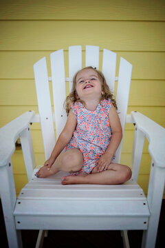 Beautiful toddler laughing in adirondack chair