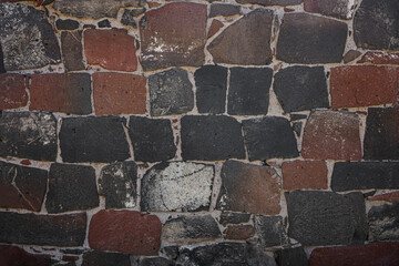 texture of brown tile wall. Background of grey tiled wall. Rectangular tile. stone wall pattern, cement seam texture. gray road granite tiles with white seams Stone backdrop. red building exterior