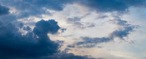 Dark blue clouds in the sky illuminated by the evening sun