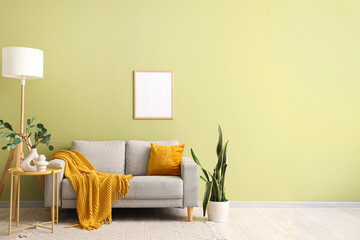 Interior of living room with grey sofa, lamp and blank frame