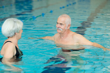 Fototapeta premium senior couple relaxing in swimming pool together