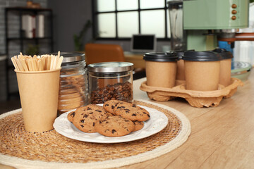 Stir sticks with cookies on table in office, closeup