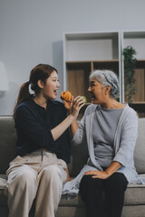 Happy asian woman daughter hugging senior mother in the kitchen room eating healthy food happy enjoying.