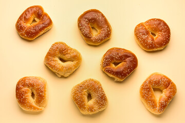Tasty bagels with sesame seeds on beige background