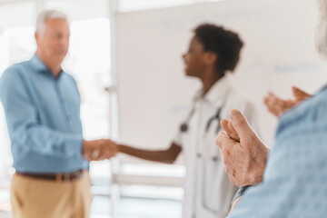 Senior applauding African American graduate, academic achievement concept
