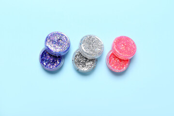 Jars of glitter on blue background