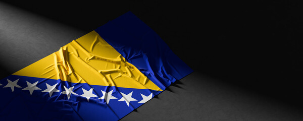 Flag of Bosnia and Herzegovina. Fabric textured Bosnia and Herzegovina flag isolated on dark background. 3D illustration