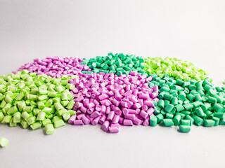 Masterbatch granules with pastel colors on a white background. Color pigment carrier polymers in the plastics industry