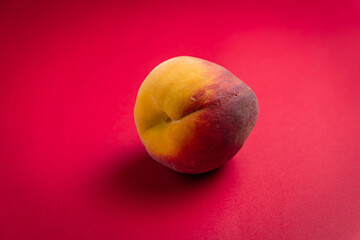 Peach fruit on red background 
