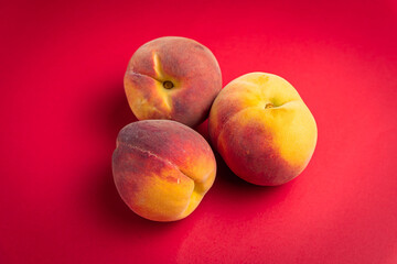 Peach fruit on red background 