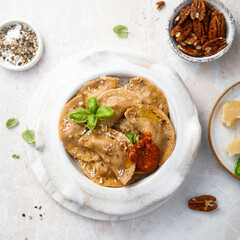 Homemade ravioli with red pesto and nuts