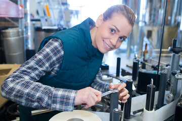 female engineer using spanner on factory conveyor
