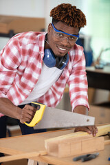 a happy male worker cutting wood