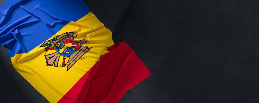 Flag of Moldova. Fabric textured Moldova flag isolated on dark background. 3D illustration
