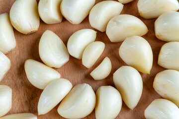 close up top view of wooden plate filled with garlic arranged in a spiral shape