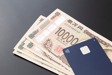 黒背景にキャッシュカードと一万円札