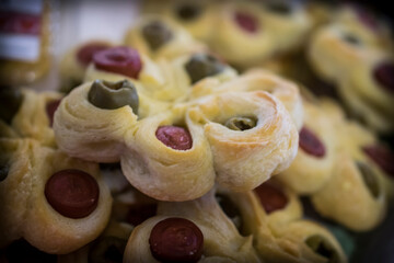 Assorted pastry snacks with wurst and olives on a table