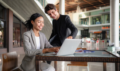 Latino man and African American businessperson brainstorming startup small business strategy together. Young multiracial businesswoman and colleague serious working on planning. Diversity people team.
