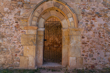 Fototapeta premium A rustic stone archway at Monasterio de San Juan de Duero in Soria, Spain. The medieval architecture and weathered stone walls reflect the monastery's rich history.