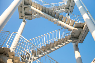 Stairs Metal Structure Outdoor - A low-angle view of a metal staircase leading upward, with a...