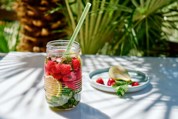 Detox drink. Infused water with raspberry, lemon and mint. Refreshing summer homemade cocktail. Fresh healthy cold beverage.