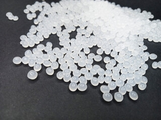 Plastic polymer granules, virgin raw material, virgin plastic resin, isolated on blue background, for presentation design catalog profile product plastic industrial manufacturing