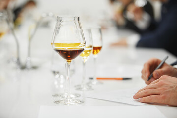 Blind tasting, close up. Sommelier makes notes on the tasting card. 