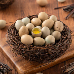 Fresh button quail eggs in a nest on wooden table background.