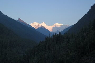 Rugged mountain peaks rise above the morning mist, shrouded in mystery and wonder. Deep valleys...