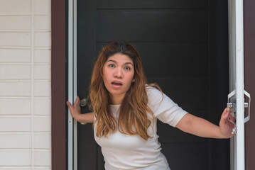 An asian woman standing right at the door shouts at her neighbor to shut up and stop making noise. POV from the street.