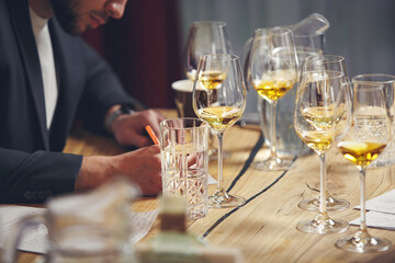 Sommelier makes notes on the tasting card. Wine blind tasting.