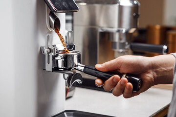 Pouring Portafilter With Freshly Ground Coffee for Espresso in Coffee Shop, Close up