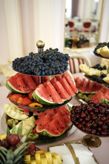 Fruit and berry buffet with watermelon, melon, cherry and grapes.