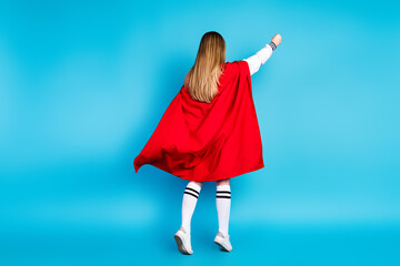 Photo of funny lovely adorable schoolgirl wear stylish outfit red cape fly air isolated on blue...
