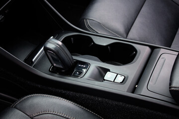 Obraz premium Close up car automatic transmission. Gear shift in new electric car. Selector automatic transmission with leather in the interior of a new modern car. Car Black leather interior.
