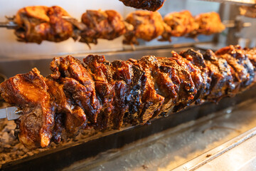 Meat Roasting On A Spit, With The Succulent, Crispy Exterior Showing Rich Colors, Suggesting A Deliciously Cooked Meal At Traditional Greek Restaurant	
