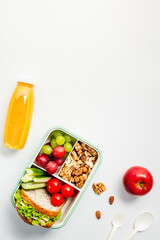 Nutritious lunchbox with a sandwich, fresh fruits, nuts, and juice. Perfect for nutrition blogs and healthy lifestyle content