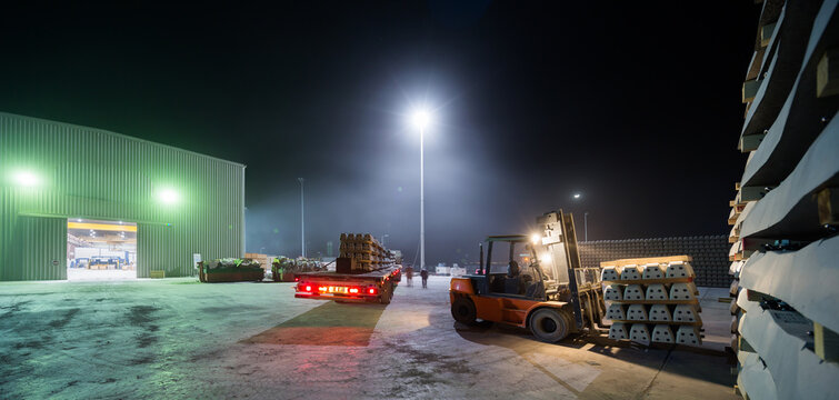 Industrial Night Scene with Railway Sleepers and Forklift