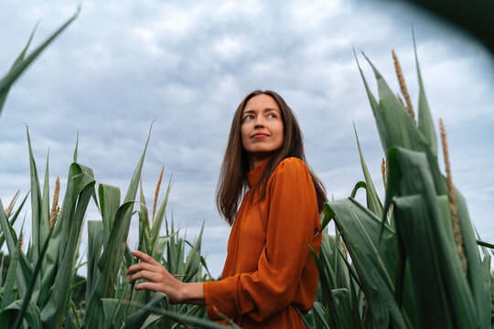 Woman in orange dress enjoying time in a cornfield