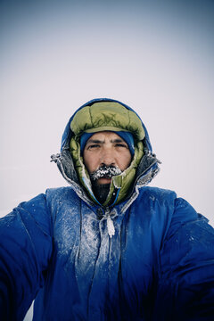 Male mountaineer in frozen gear braves harsh winter