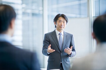 プレゼンテーションを行うスーツを着た日本人ビジネスマン
