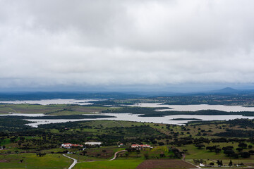 View of Alqueva Dam waters from Monsaraz, with Spanish lands in the background on an autumn afternoon. Serene, expansive landscape blending water and earth under a mellow sky.