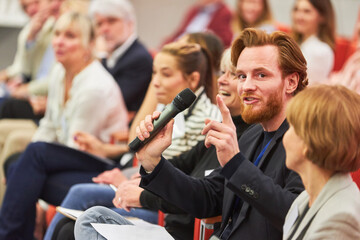 Businessman answering in business conference at auditorium