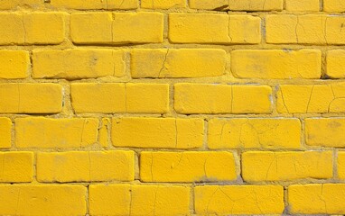 Obraz premium A close-up of a yellow brick wall, showing texture and small cracks. Ideal for backgrounds, construction, or urban design themes.