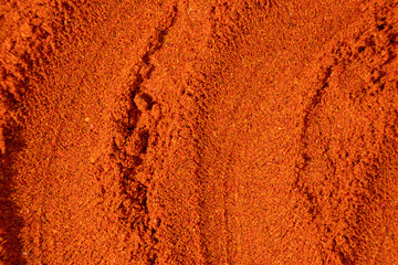 Ground paprika, red terracotta spice background, art in cooking.