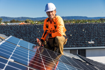 Solar panel technician with drill installing solar panels