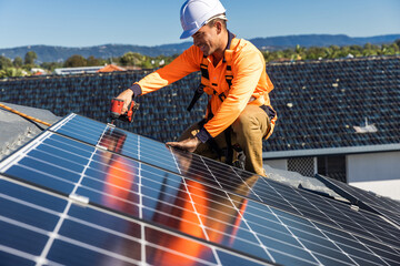 Solar panel technician with drill installing solar panels